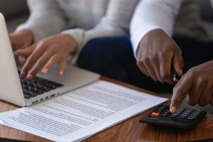 Close up of multiracial couple calculating finances paying online